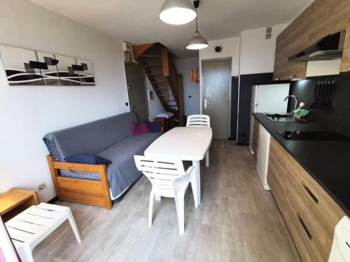 Il dispose d'une cuisine et d'un salon avec une table et un canapé. dans l'établissement Résidence Les Nefs Des Sables - APPT T2 CAB OU MEZZ 6 couchages PORT LEUCATE. Réf: 2NEF_33K3 MAE-5534, à Port-Leucate