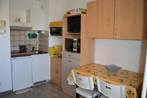 une petite cuisine avec une table et des chaises. dans l'établissement Résidence Belle Plage - 2 Pièces 5 couchages PORT LEUCATE. Réf: 3BP_15D MAE-5544, à Port-Leucate