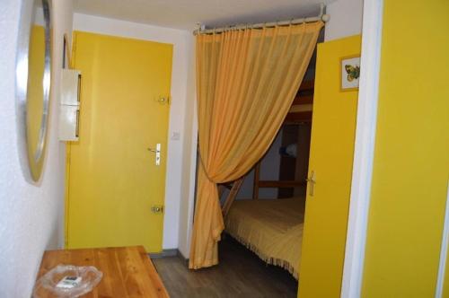 une chambre avec un rideau jaune et un lit dans l'établissement Résidence Belle Plage - 2 Pièces 5 couchages PORT LEUCATE. Réf: 3BP_15D MAE-5544, à Port-Leucate