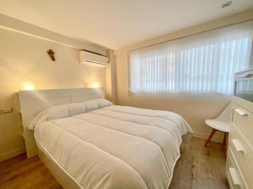 a large white bed in a room with a window at White House Nervion in Benidorm
