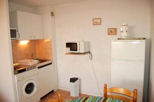 une cuisine avec un réfrigérateur et une machine à laver dans l'établissement Résidence Grande Bleue - 2 Pièces 4 couchages PORT LEUCATE MAE-5614, à Port-Leucate