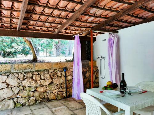 a kitchen with a white table and a stone wall at Residence Mariposa - Apartments & Rooms in Salve