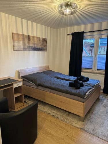 ein Schlafzimmer mit einem Bett, einem Tisch und einem Kronleuchter in der Unterkunft Ruhige Wohnung in Nethen beim Beach Club in Rastede