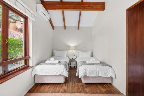 two beds in a small room with a window at San Lameer Villa 2914 - 3 Bedroom Classic - 6 pax - San Lameer Rental Agency in Southbroom