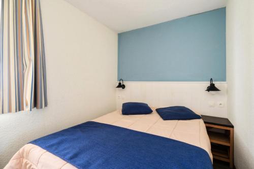 une chambre avec un lit avec deux oreillers bleus dans l'établissement Résidence Port du Crouesty - maeva Home - Appartement 2 pièces 5 personnes - Confort - vue Mer MAE-4764, à Arzon