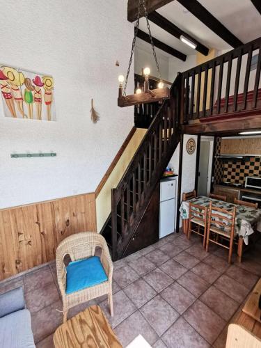 un salon avec un escalier et une table dans l'établissement Résidence MAISONS DES SABLES 4 - 2 Pièces pour 6 Personnes 44, à Port-Leucate