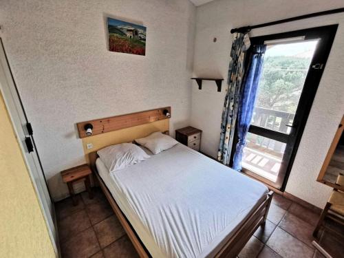 une petite chambre avec un lit et une fenêtre dans l'établissement Résidence MAISONS DES SABLES 4 - 2 Pièces pour 6 Personnes 44, à Port-Leucate