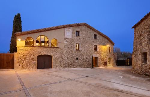 ein großes Steingebäude mit einer Auffahrt davor in der Unterkunft Turisme Rural Mas Ametller - Casa Gran in Fontclara