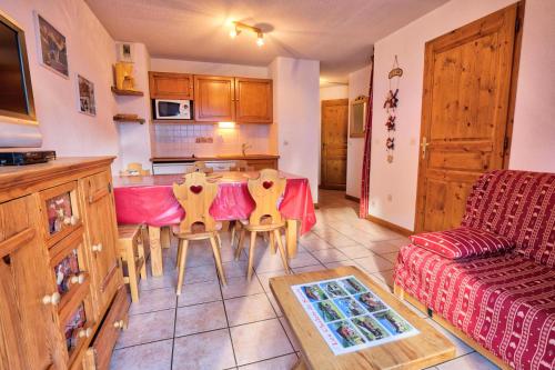 une cuisine et un salon avec une table et des chaises dans l'établissement Résidence Les Oursons - Appartement typique au pied des pistes du Mont Rond MAE-3034, à Notre-Dame-de-Bellecombe