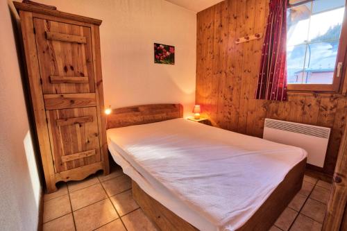 une petite chambre avec un lit et une fenêtre dans l'établissement Résidence Les Oursons - Appartement typique au pied des pistes du Mont Rond MAE-3034, à Notre-Dame-de-Bellecombe
