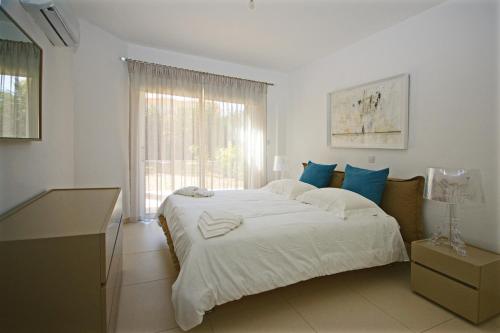 a bedroom with a large white bed and a window at Resitour - Aphrodite Gardens in Paphos City