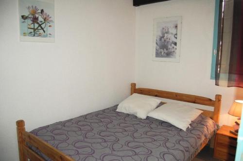 une petite chambre avec un lit avec deux oreillers dans l'établissement Résidence Belle Plage - VILLA 3 PIECES 6 couchages PORT LEUCATE. Réf: 3BP_11F MAE-5764, à Port-Leucate