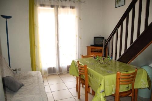 une salle à manger avec une table et un chiffon jaune dans l'établissement Résidence Belle Plage - VILLA 3 PIECES 6 couchages PORT LEUCATE. Réf: 3BP_11F MAE-5764, à Port-Leucate