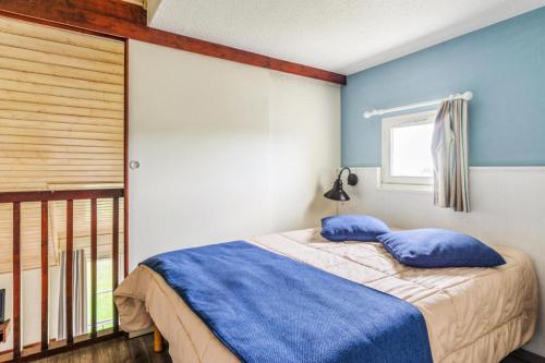 une chambre avec des murs bleus et un lit avec des oreillers bleus dans l'établissement Résidence Port du Crouesty - maeva Home - Appartement duplex 3 pièces 7 personnes Confort MAE-4800, à Arzon