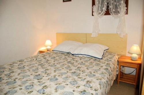 a bedroom with a bed with two night stands and two lamps at Résidence BELLE PLAGE - 2 Pièces pour 4 Personnes 44 in Port Leucate
