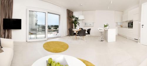 una sala de estar blanca con mesa y sillas en Apartments Deja Views, en Split