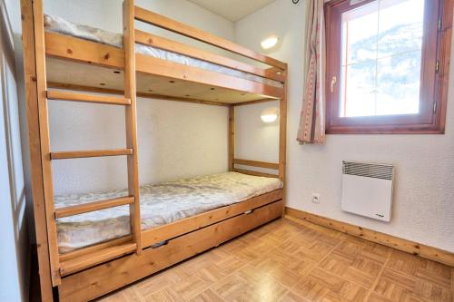 a room with two bunk beds and a window at Les Chalets Des Evettes - 3 Pièces pour 6 Personnes 04 in Notre-Dame-de-Bellecombe