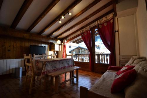 - un salon avec une table, un canapé et une télévision dans l'établissement Résidence La Beguette - Chaleureux appartement au pied des pistes MAE-3144, à Notre-Dame-de-Bellecombe