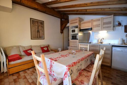 - une cuisine et une salle à manger avec une table et un canapé dans l'établissement Résidence La Beguette - Chaleureux appartement au pied des pistes MAE-3144, à Notre-Dame-de-Bellecombe