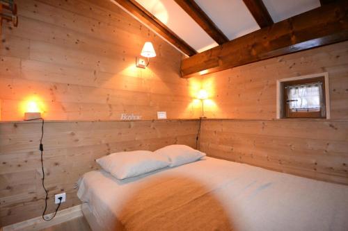 a bedroom with a bed in a wooden wall at Résidence La Beguette - 2 Pièces pour 5 Personnes 44 in Notre-Dame-de-Bellecombe