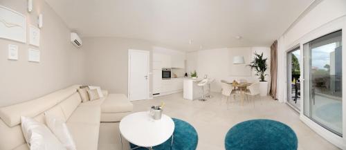 a white living room with a white couch and a table at Apartments Deja Views - Žnjan beach in Split