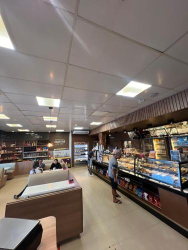 a grocery store aisle with people standing in a store at Hotel PetroShop in Palmas
