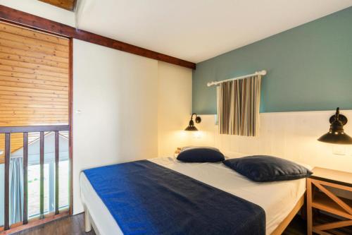 une chambre avec un lit avec deux oreillers dessus dans l'établissement Résidence Port du Crouesty - maeva Home - Appartement duplex 3 pièces 7 personnes Confort MAE-4807, à Arzon