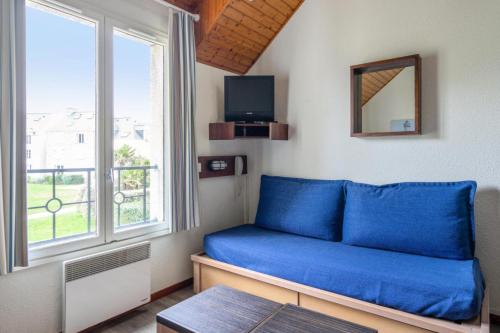 un salon avec un canapé bleu et une fenêtre dans l'établissement Résidence Port du Crouesty - maeva Home - Appartement duplex 3 pièces 7 personnes Confort MAE-4811, à Arzon