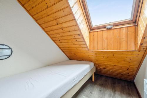 Cette petite chambre dispose d'un lit et d'une fenêtre. dans l'établissement Résidence Port du Crouesty - maeva Home - Appartement duplex 3 pièces 7 personnes Confort MAE-4806, à Arzon