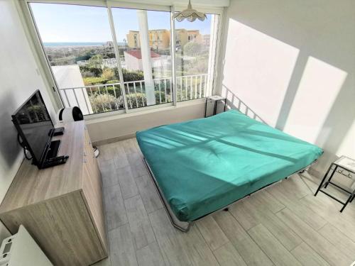 une chambre avec un lit et une grande fenêtre dans l'établissement Résidence Les Cyclades - Appartement T2 avec deux loggias - 6 couchages PORT LEUCATE. Réf: 2CYC_12A MAE-5984, à Port-Leucate