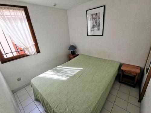 une chambre avec un lit vert et une fenêtre dans l'établissement Résidence Les Captivantes - Villa trois pièces mezzanine face à la mer avec garage à Port Leucate. Réf: 1CAPT_H3 MAE-5964, à Port-Leucate