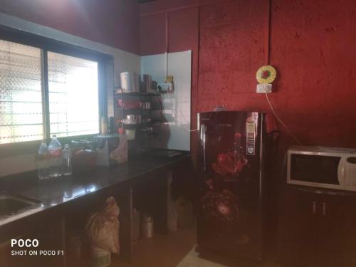 a kitchen with a counter and a microwave and a refrigerator at Om Gajanan Farms in Nerur