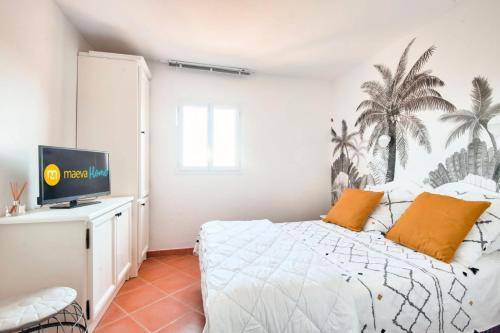 - une chambre avec un lit et une télévision sur un bureau dans l'établissement Village Pont Royal en Provence - maeva Home - Appartement climatisé avec terrasse 4 pièces 8 personnes - Prestige - super Home MAE-6210, à Mallemort