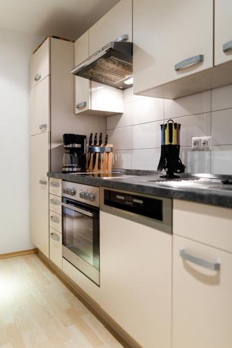a kitchen with white cabinets and a stove top oven at Ferienhaus Panorama Mosel in Reil