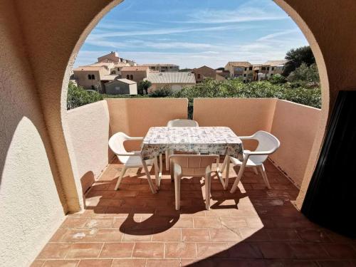 un patio avec une table et des chaises sur un balcon dans l'établissement Résidence Maisons Des Sables 4 - 2 Pièces 4 couchages PORT LEUCATE. Réf: 2MS4_59E MAE-6014, à Port-Leucate