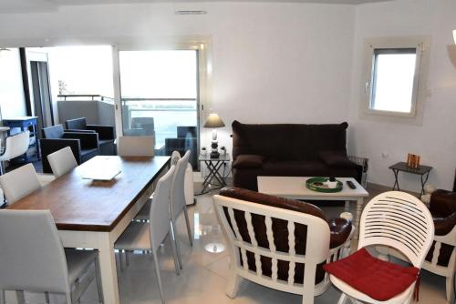 un salon avec une table, des chaises et un canapé dans l'établissement Résidence Soleil Levant 2 - APPT T2 CAB OU MEZZ 6 couchages LE BARCARES MAE-6084, à Port-Leucate