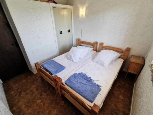 - une chambre avec un lit en bois et 2 oreillers dans l'établissement Résidence Maisons Des Sables 4 - 2 Pièces 4 couchages PORT LEUCATE. Réf: 2MS4_59E MAE-6014, à Port-Leucate