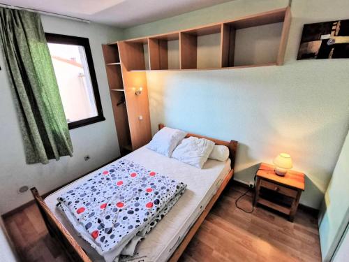 um quarto com uma cama, uma janela e uma mesa em Résidence MAISONS DE LA PLAGE - Maisons & Villas pour 6 Personnes 074 em Port Leucate