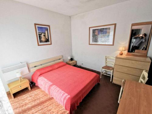 - une chambre avec un lit rouge et une commode dans l'établissement Résidence Les Zodiaques - Appartement 3 Pièces 5 couchages PORT LEUCATE. Réf: 1ZOD_C2 MAE-6094, à Port-Leucate