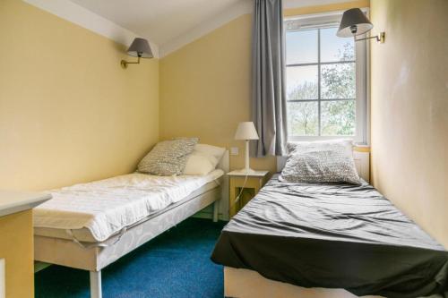 une petite chambre avec deux lits et une fenêtre dans l'établissement Les Maisons de Port Bourgenay - maeva Home - Maison 4 pièces 8 personnes Sélection MAE-6611, à Talmont-Saint-Hilaire