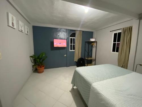 a bedroom with a white bed and a blue wall at Habitación cerca del aeropuerto #1 