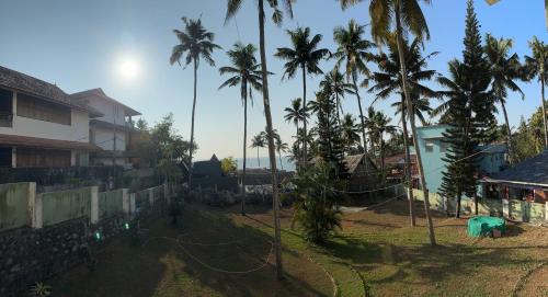 a view of a yard with palm trees at hello beach view resorts in Varkala