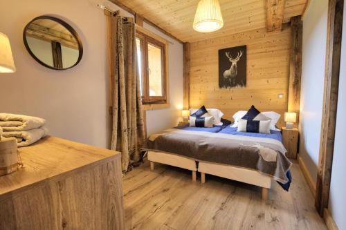 um quarto com uma cama num chalé de madeira em Chalet La Chalee - 5 Pièces pour 8 Personnes 64 em Notre-Dame-de-Bellecombe