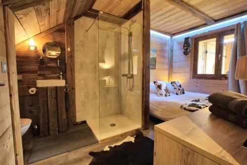 uma casa de banho com chuveiro e uma cama num quarto em Chalet La Chalee - 5 Pièces pour 8 Personnes 64 em Notre-Dame-de-Bellecombe