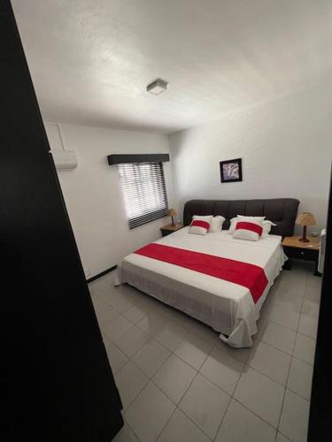 a bedroom with a large bed with a red blanket at RESIDENCE PLEIN SOLEIL near Pereybere Beach - Only 200 Metres Away! in Pereybere