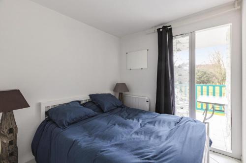 une chambre avec un lit avec des draps bleus et une fenêtre dans l'établissement Résidence Port Bourgenay - maeva Home - Appartement 2 pièces 7 personnes - Sélection MAE-7339, à Talmont-Saint-Hilaire