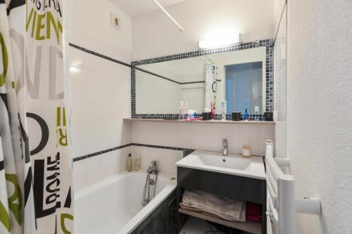 une salle de bain avec un lavabo et une baignoire dans l'établissement Résidence Port Bourgenay - maeva Home - Appartement 2 pièces 7 personnes - Sélection MAE-7339, à Talmont-Saint-Hilaire