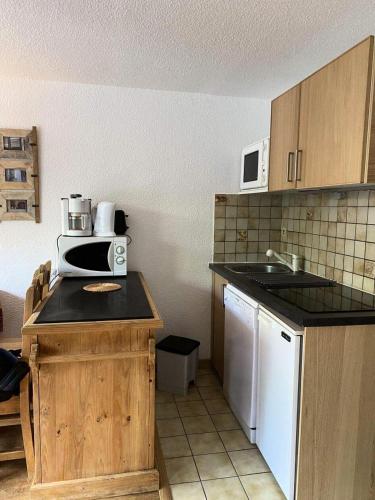 - une cuisine avec un comptoir et un four micro-ondes dans l'établissement Résidence Rochechateau - Studio cabine 4 personnes 2 exposé Ouest MAE-4234, à Valloire