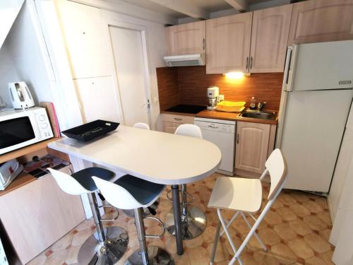 une petite cuisine avec une table et des chaises blanches dans l'établissement Résidence Equateur - APPT T2 CAB OU MEZZ 6 couchages PORT LEUCATE. Réf: 2MS3_113 MAE-6234, à Port-Leucate