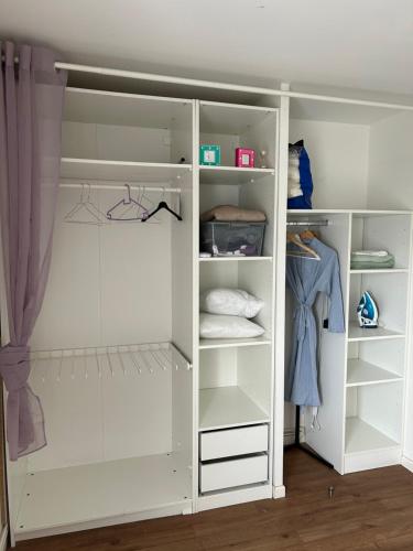 a white closet with white shelves at Duplex luxury à 15’ JOP stade de France in Saint-Ouen